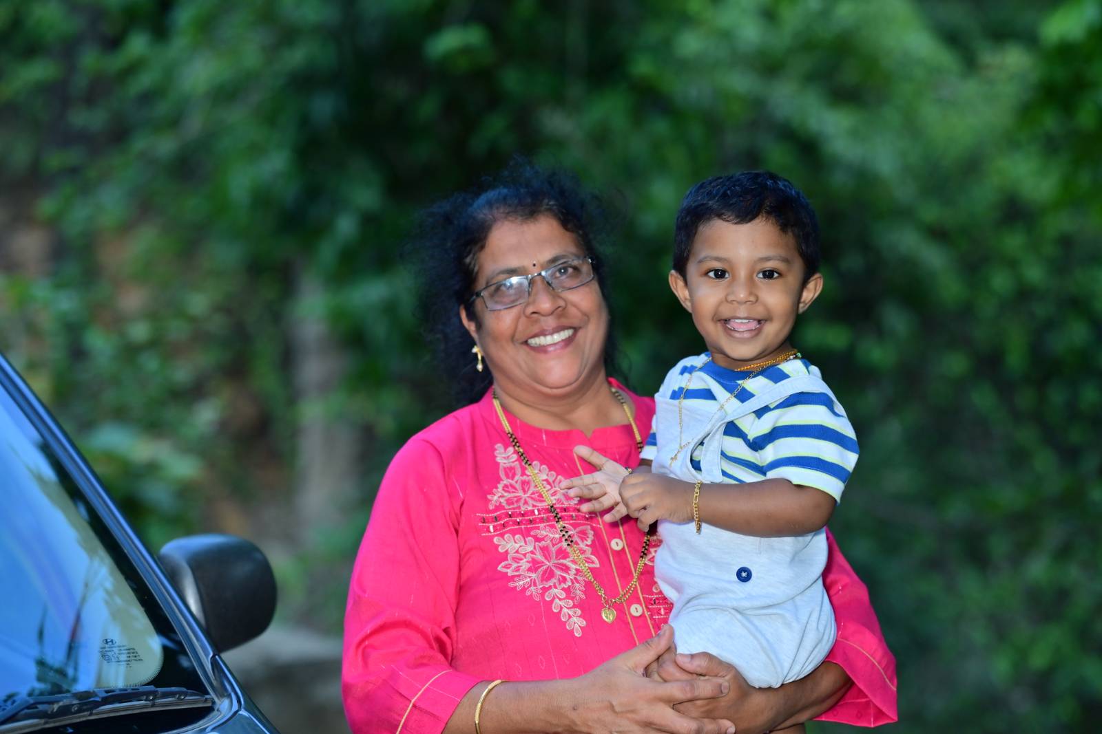 Moovitha's mother holding her grandson — three generations of love