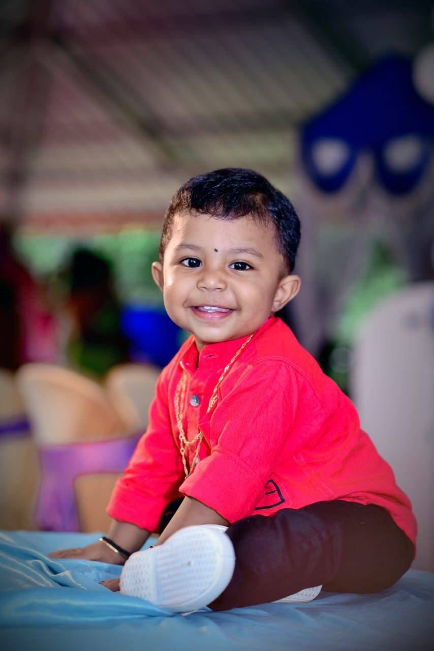 Moovitha's son — smiling in a red kurta